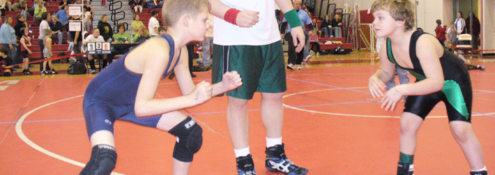 Two youth facing each other in beginning of wrestling match