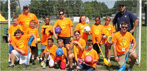 Youth sports team posing for a picture in front of soccer goal